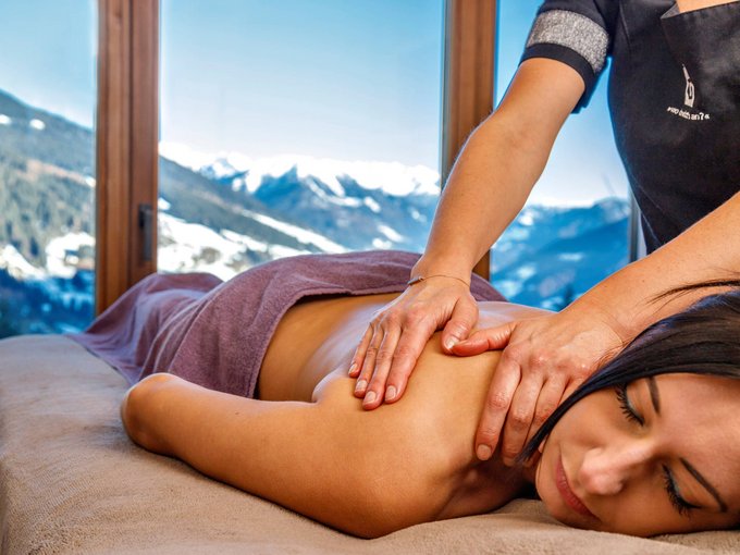 Home Erlebnisort Gassenhof Frau bekommt Rückenmassage mit Bergblick durch großes Fenster