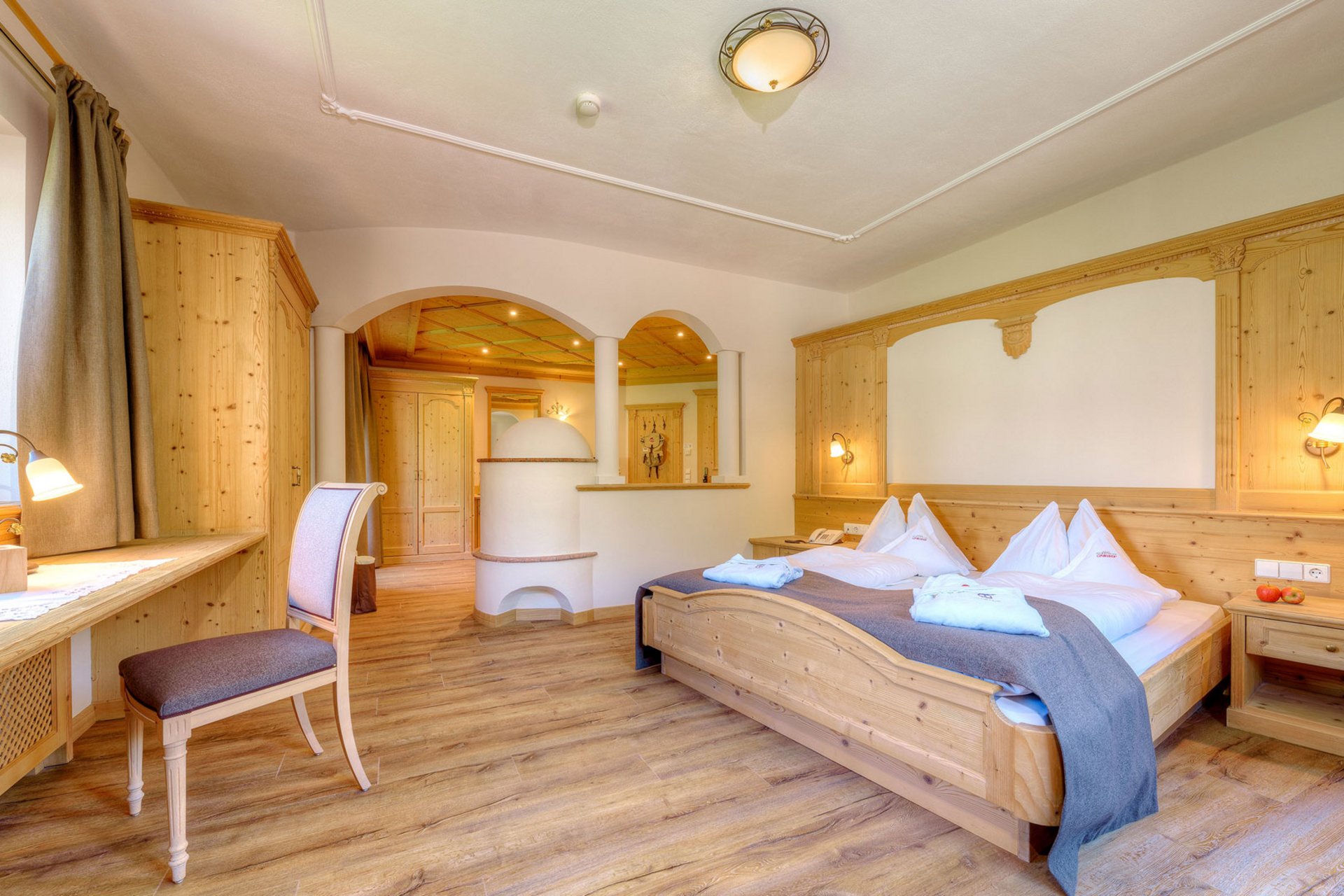 Home Erlebnisort Gassenhof Gemütliches Hotelzimmer mit Holzmöbeln und Doppelbett