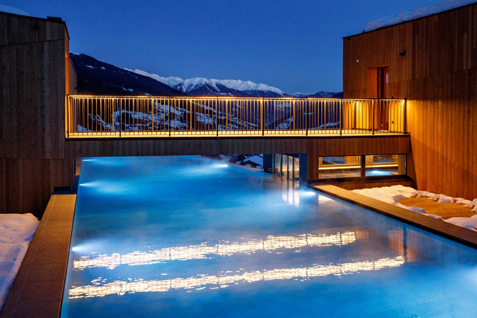 Home Erlebnisort Gassenhof Beleuchteter Außenpool bei Nacht mit Bergblick und Schnee