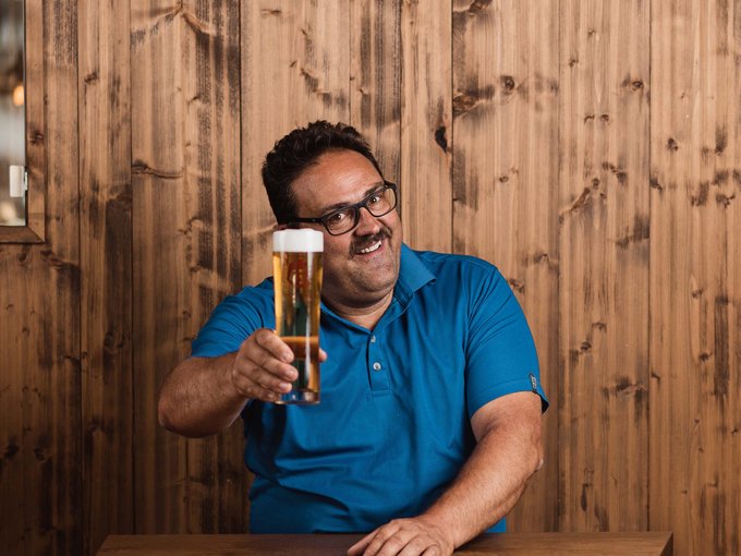 The Gratznbräu brewery Man in blue shirt holding a beer glass in a rustic wooden interior