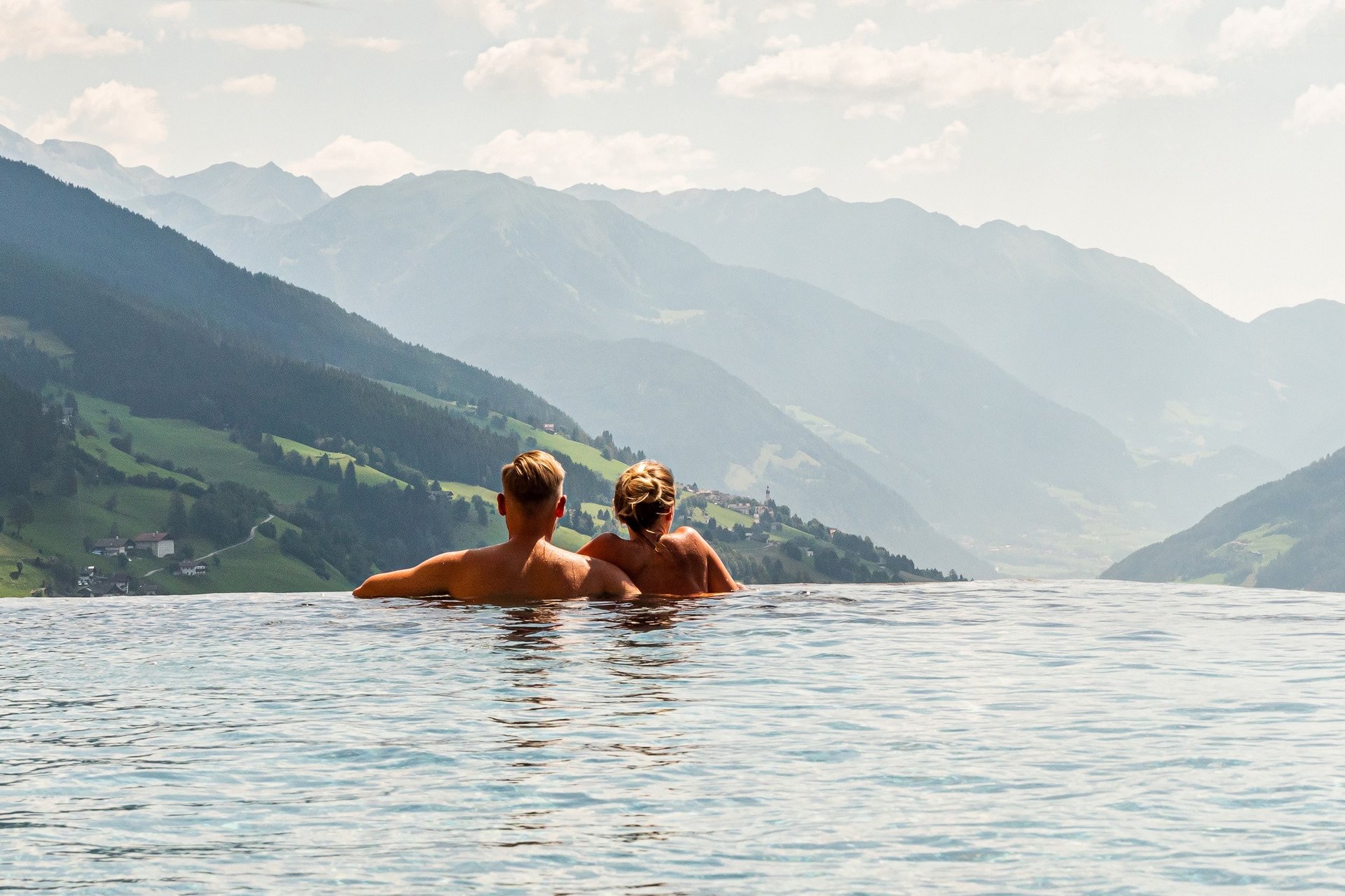 Home Erlebnisort Gassenhof Paar entspannt im Infinity-Pool mit Blick auf Berglandschaft